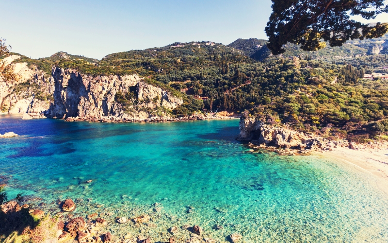 Malowniczy krajobraz Korfu z widokiem na zatokę i zielone wzgórza, idealne miejsce na wakacje.